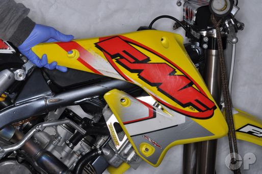 Remove the radiator shroud on the RMZ250 motorcycle.