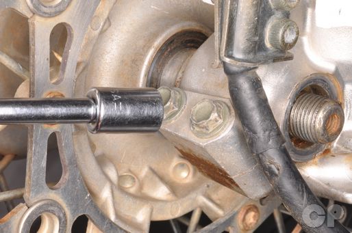 Loosen the YZ125 front axle pinch bolts to remove the front wheel.